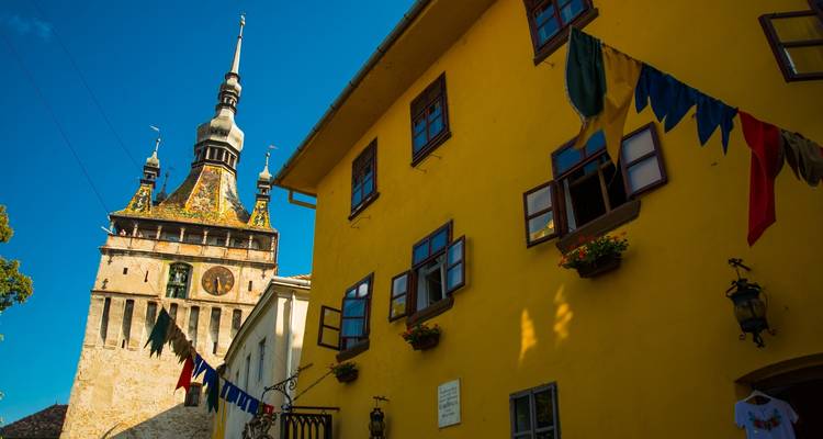 Bunte mittelalterliche Stadt mit Turm und Fahnen.