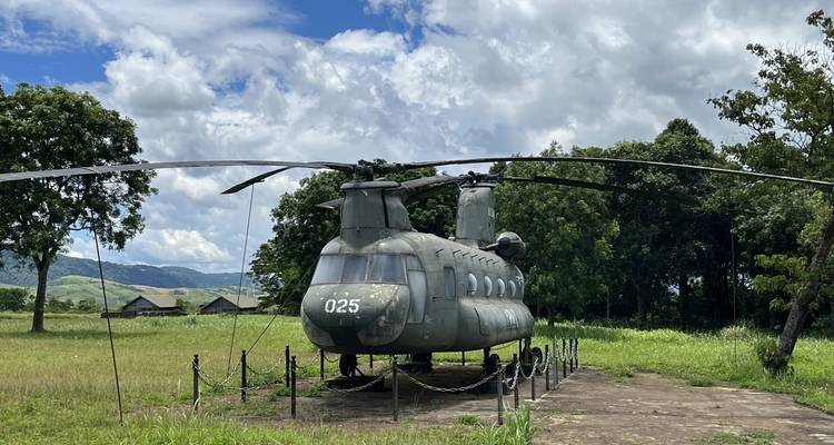 Helicopter on display outdoors with trees in the background.