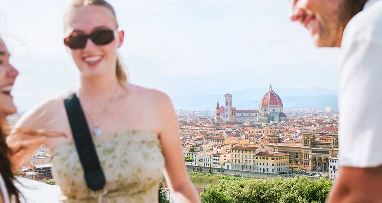 Amigos riendo con vista panorámica del horizonte de terracota de Florencia y el Duomo.