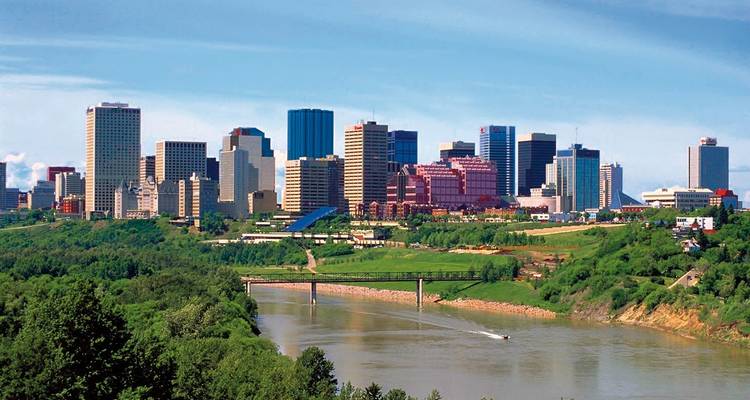 Daglichtse skyline van Edmonton met de North Saskatchewan rivier en weelderige groene riviervallei op de voorgrond.