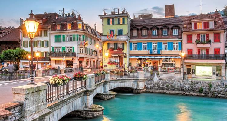 Colorful buildings along a small bridge over a river in Interlaken.