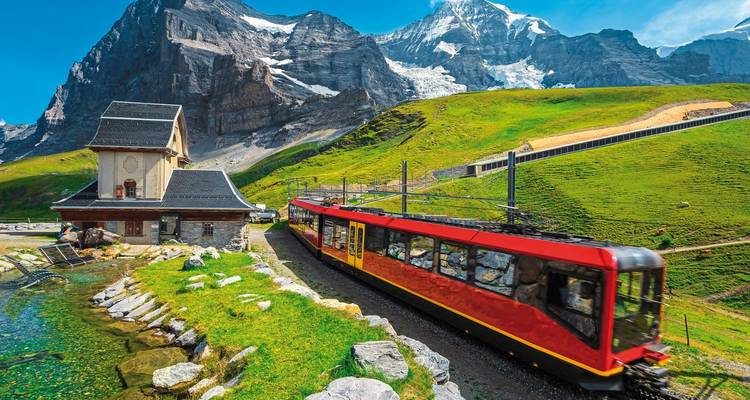 A mountain train with snowy peaks in the background in Jungfrau.