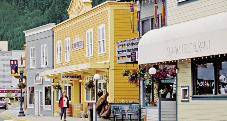 Een straatbeeld met kleurrijke gebouwen en wandelende mensen.