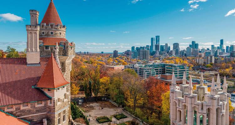 Luchtfoto van Casa Loma in Toronto met de skyline van de stad in herfstkleuren.