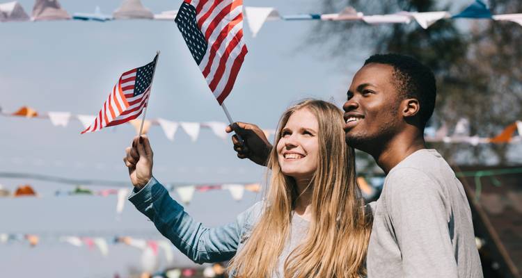 Couple agitant des drapeaux américains lors d'un festival en plein air