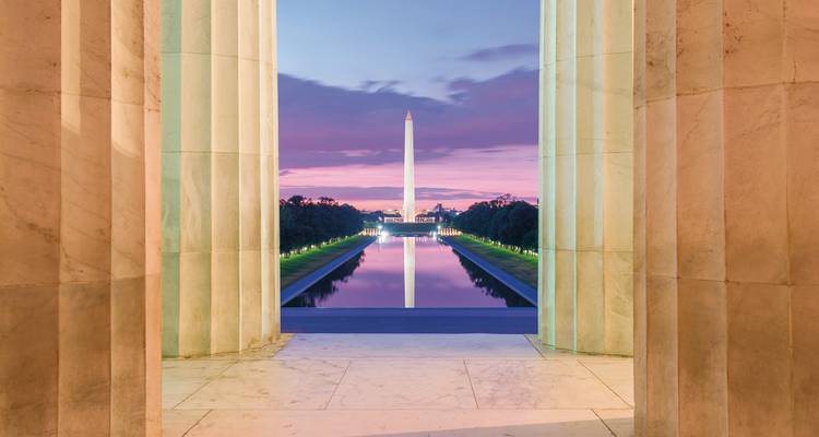 Washington Monument through the columns of the Lincoln Memorial at twilight.