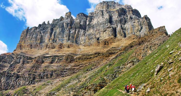 Randonneurs gravissant un sentier de montagne escarpé.