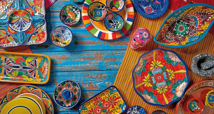 Poterie mexicaine aux couleurs vives disposée sur une table en bois.