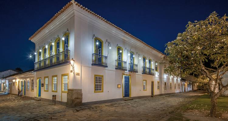 Bâtiment colonial à l'architecture ornée illuminé la nuit.