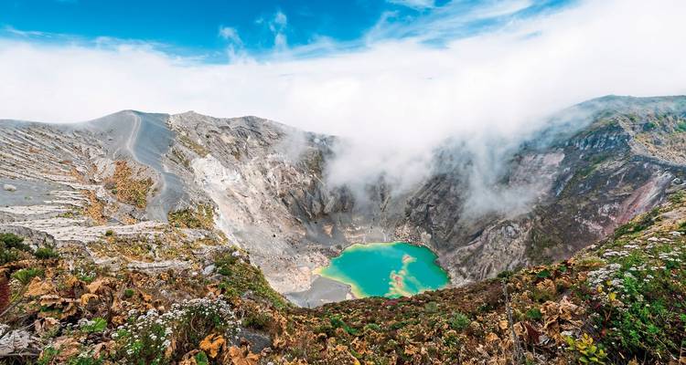 Kraters van een vulkaan met een turquoise meer op de bodem.