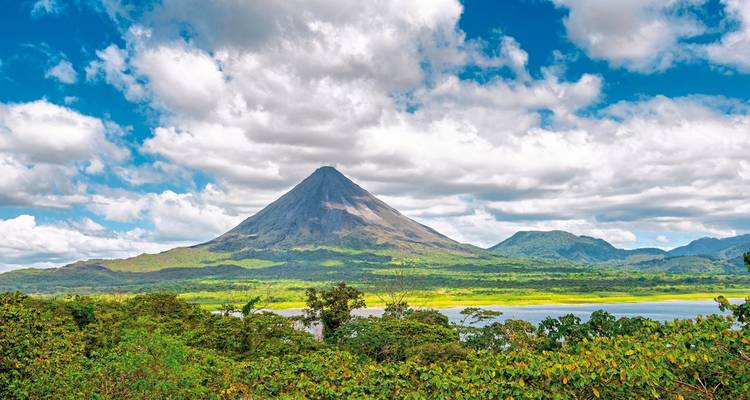 Vulkanische berg met wolken en weelderig bos.