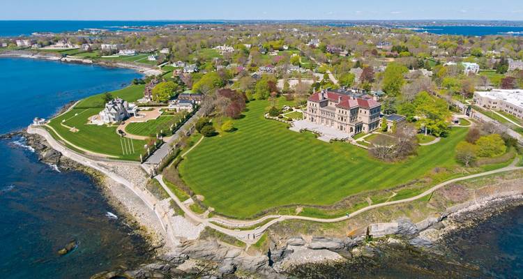 Aerial view of a coastline with a mansion and gardens.