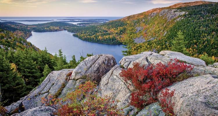 Mountainous coastline with dense forests and a lake.
