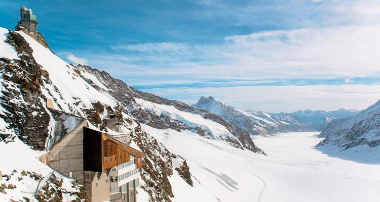 Paisaje montañoso nevado con observatorio