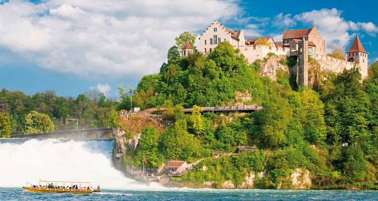 Castle above Rhine Falls with a tour boat on the river