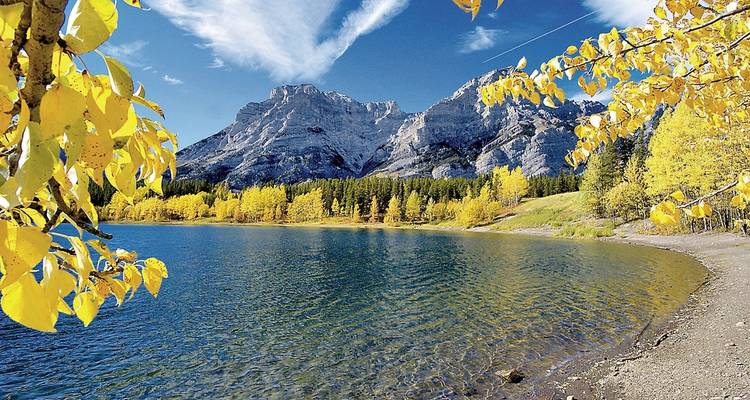 Un magnifique lac entouré de montagnes et de feuillage automnal.
