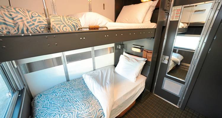 Intérieur d'une cabine-couchettes de train avec lits superposés.
