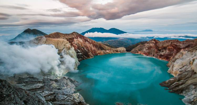 Cratère volcanique avec vapeur et lac bleu