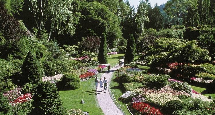 Menschen, die in einem wunderschön gepflegten Garten spazieren gehen.