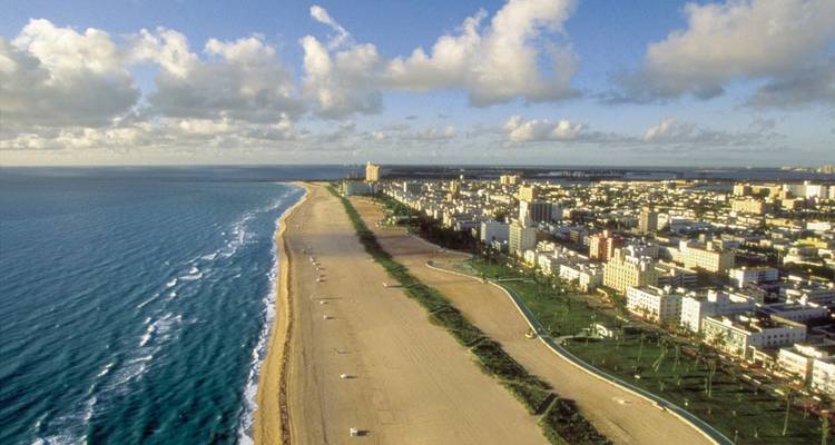 Vue panoramique du rivage de South Beach s'étendant à l'horizon avec le paysage urbain et l'océan bleu.