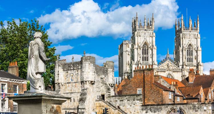York Minster met een oud standbeeld en levendige hemelachtergrond.