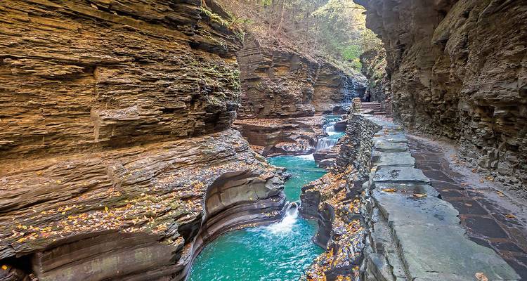 Pintoresco cañón con agua fluyendo entre paredes rocosas.