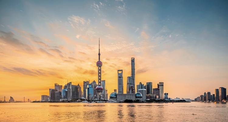 Skyline-uitzicht met moderne wolkenkrabbers bij zonsondergang aan het water.