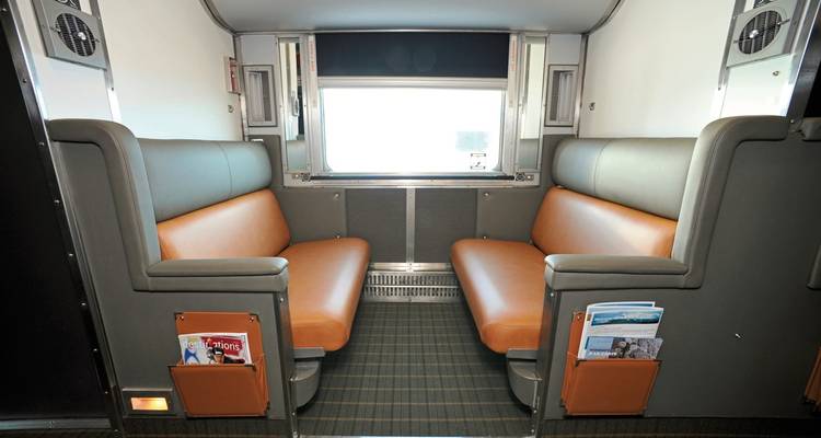 Zitruimte in een trein met bruine en grijze stoelen.