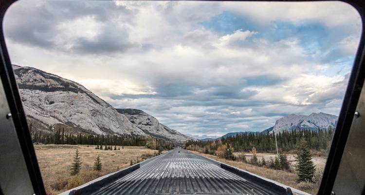 Uitzicht vanuit een trein met een schilderachtig berglandschap.