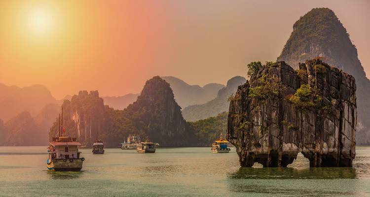 Bateaux naviguant dans la baie d'Ha Long avec des karsts calcaires.