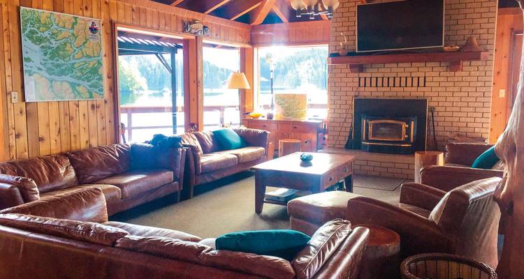 Gezellig interieur van een hut met leren banken en een open haard.