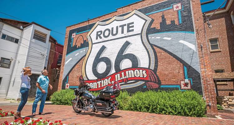 Een muurschildering van Route 66 geschilderd op een muur met mensen die ernaar kijken.