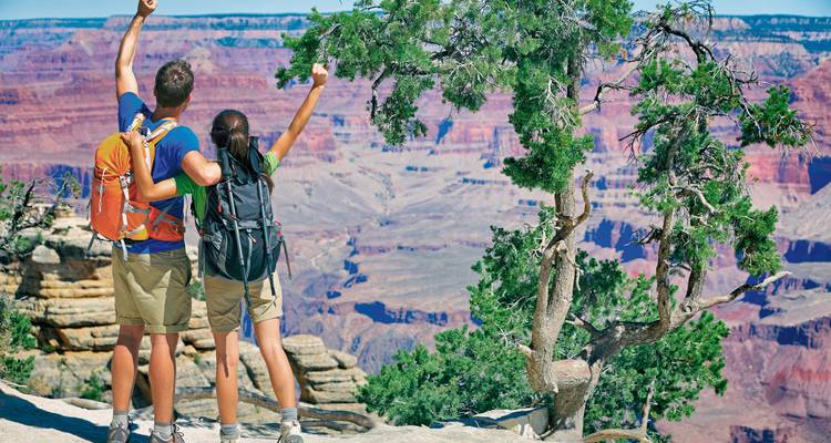 Zwei Personen genießen die Aussicht am Grand Canyon.