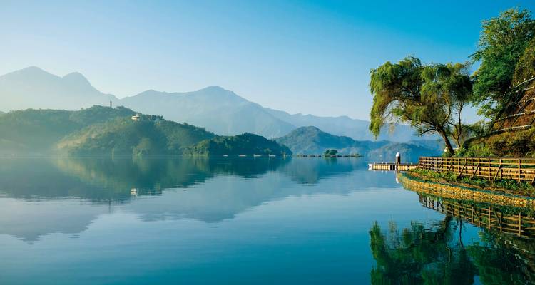 Un lac serein avec des montagnes en arrière-plan.