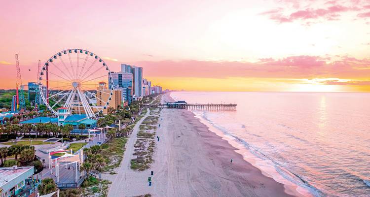 Beachfront with Ferris wheel at sunset