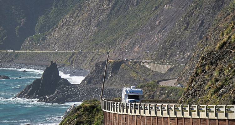 Scenic coastal highway with cliffs and ocean view.