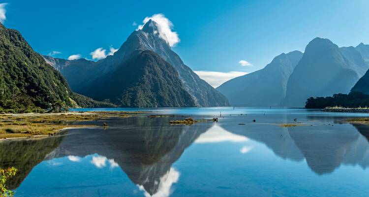 Paysage majestueux de fjord avec une surface d'eau tranquille reflétant les montagnes.