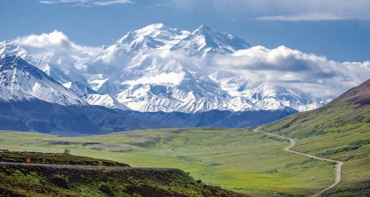 Atemberaubende Berglandschaft mit einem schneebedeckten Gipfel unter blauem Himmel.
