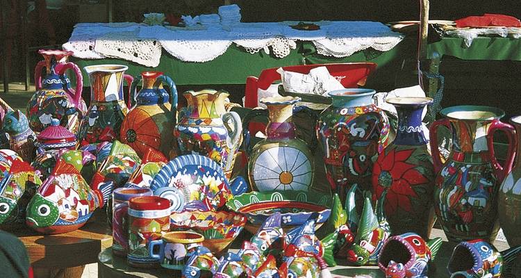 Buntes Töpferwaren ausgestellt auf einem Marktstand.