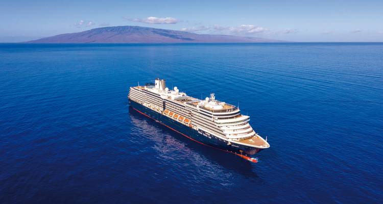Bateau de croisière naviguant en eaux libres avec de la terre au loin.