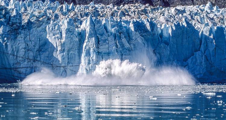 Glaciar masivo con un dramático evento de desprendimiento hacia el mar.
