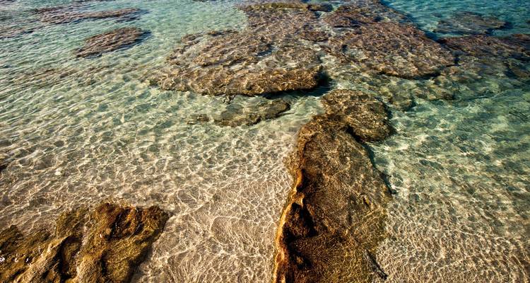 Ondiep water met zichtbare rotsformaties.