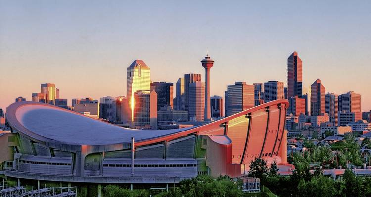 Horizon d'une ville moderne au coucher du soleil avec un toit de stade unique.