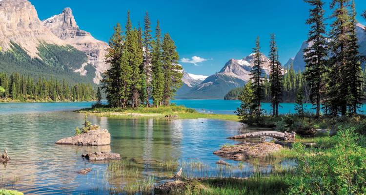 A serene lake surrounded by dense forests and mountains.