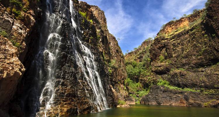 Wasserfall, der einen steilen Felsen hinunterfließt in ein Becken darunter.