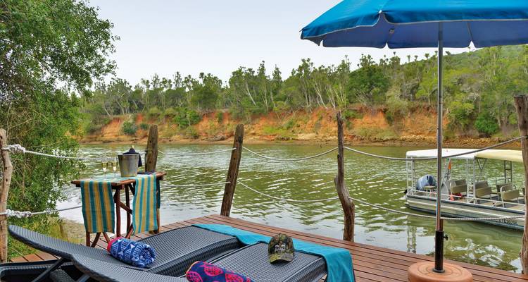Configuration relaxante au bord de la rivière avec une terrasse et des chaises.