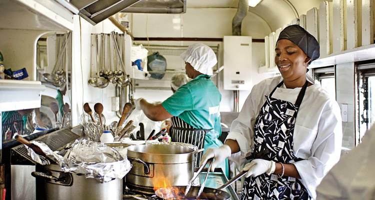 Intérieur d'une cuisine de train avec des chefs au travail.