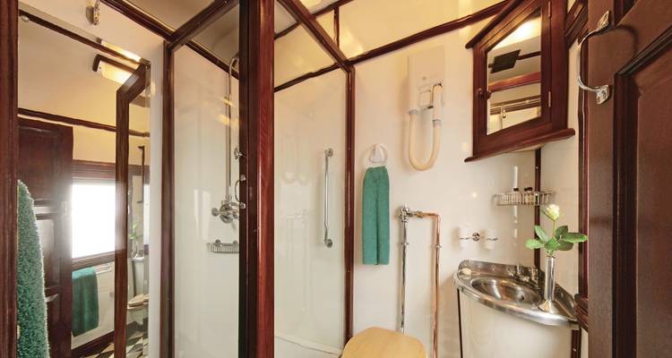 Luxuriöses Zugbadezimmer mit Holzakzenten und moderner Ausstattung.