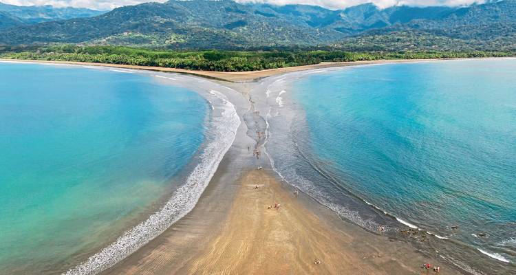 U-shaped sand formation extending into the ocean.