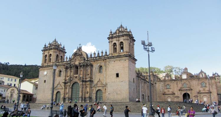 Historische Kathedrale auf einem belebten städtischen Platz mit Menschen.